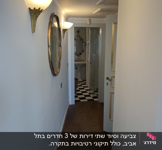 מסדרון עם קירות צבועים בלבן ותאורה על הקיר